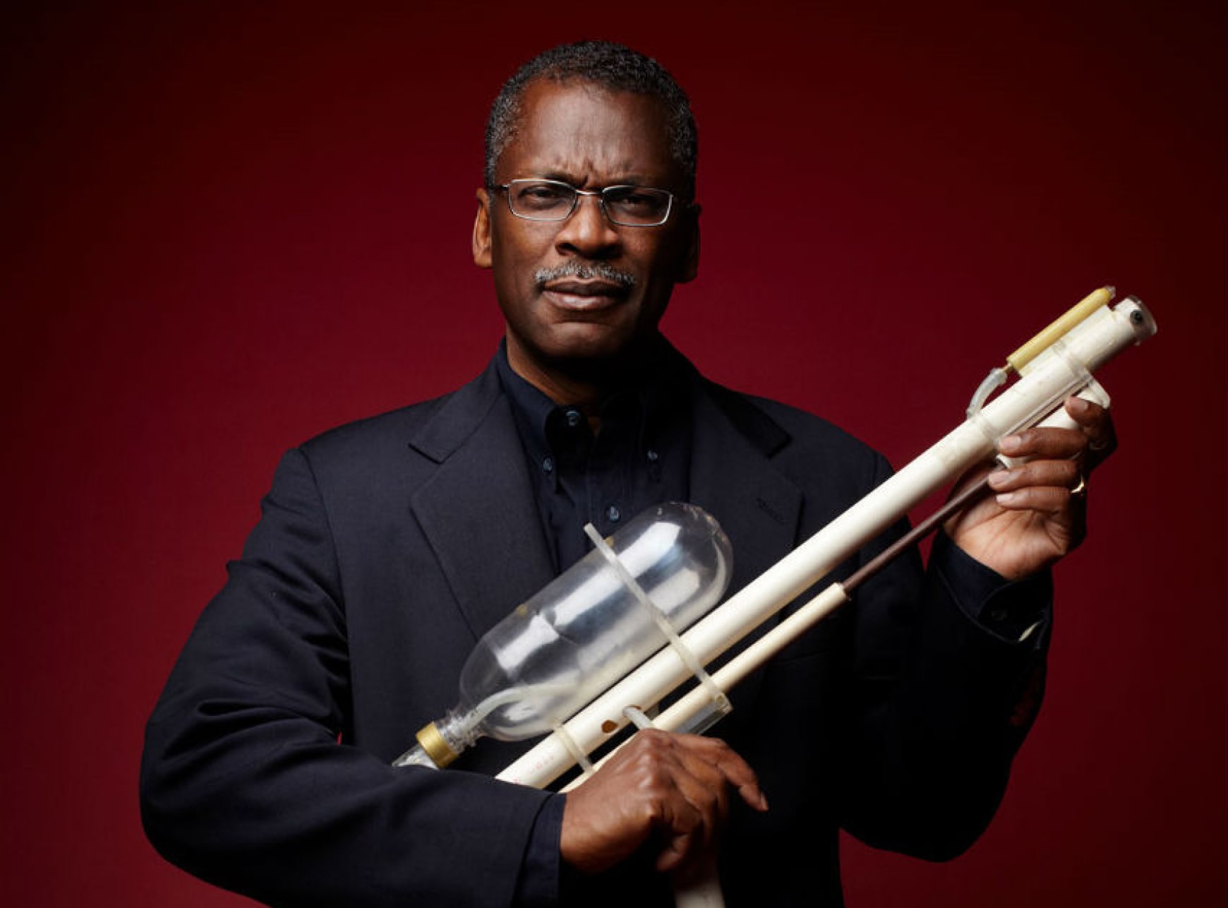 Lonnie Johnson holding the original Super Soaker prototype, illustrating early-stage concept development and invention.